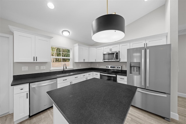 kitchen featuring white cabinetry, sink, a center island, light hardwood / wood-style floors, and appliances with stainless steel finishes