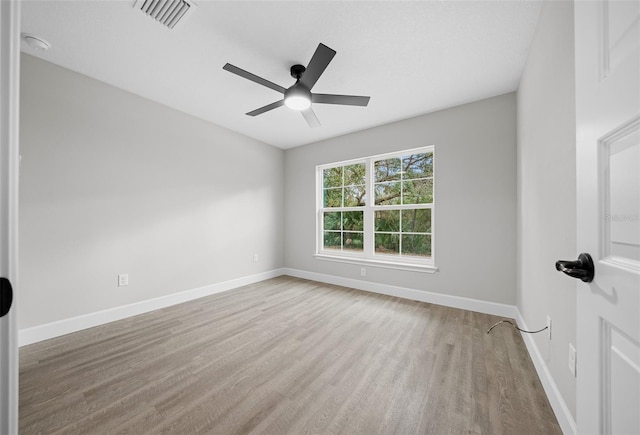 empty room with ceiling fan and light hardwood / wood-style flooring