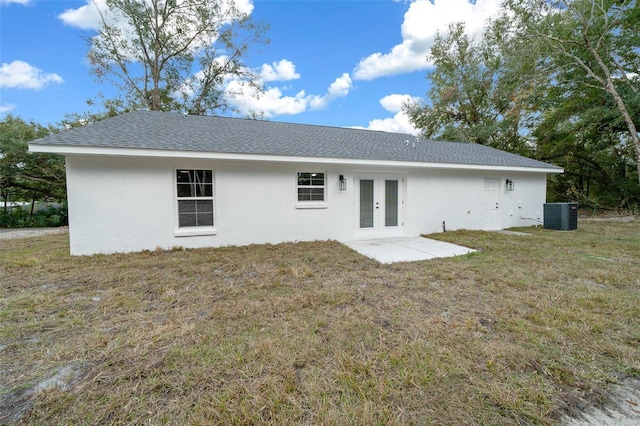 rear view of house featuring a lawn, french doors, and cooling unit