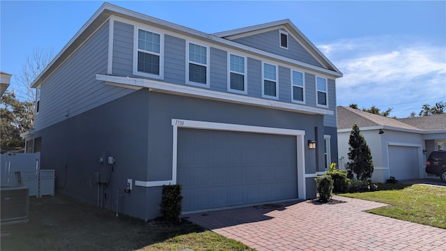 view of front of house with a front lawn, cooling unit, and a garage