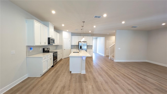 kitchen with white cabinets, stainless steel appliances, and a kitchen island with sink