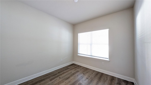 empty room with dark wood-type flooring and lofted ceiling