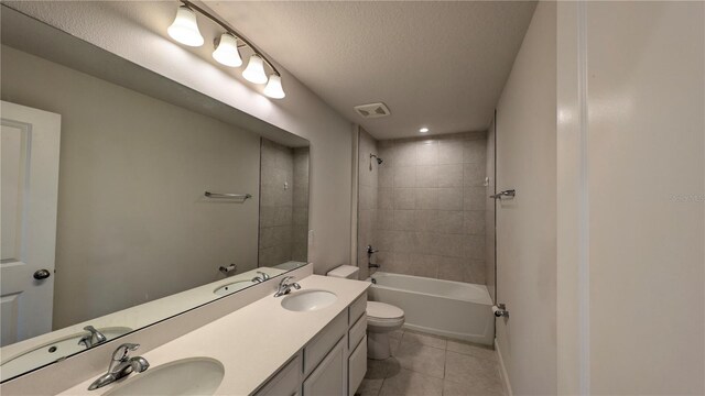 full bathroom featuring vanity, a textured ceiling, tile patterned flooring, toilet, and tiled shower / bath