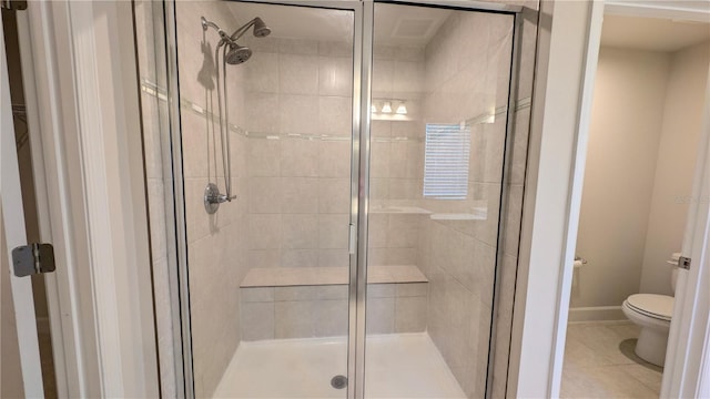 bathroom featuring tile patterned flooring, an enclosed shower, and toilet