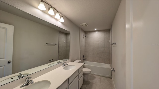 full bathroom featuring tiled shower / bath combo, toilet, a textured ceiling, tile patterned floors, and vanity