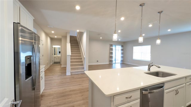 kitchen featuring an island with sink, appliances with stainless steel finishes, sink, and white cabinetry