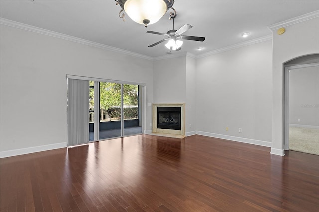 unfurnished living room with ceiling fan, crown molding, a high end fireplace, and dark wood-type flooring