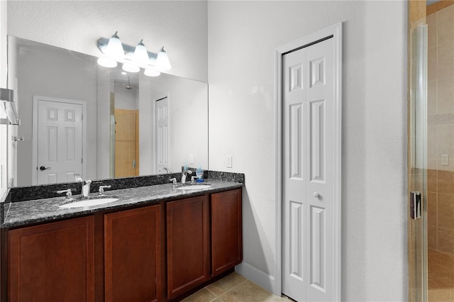 bathroom with tile patterned flooring, vanity, and an enclosed shower