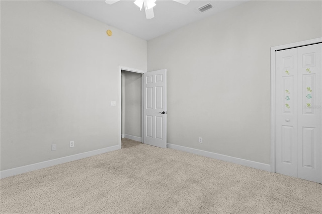 unfurnished bedroom featuring a closet, light colored carpet, and ceiling fan