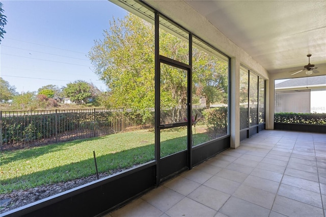 unfurnished sunroom featuring ceiling fan