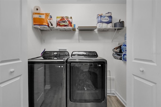 laundry area with washer and clothes dryer and hardwood / wood-style flooring