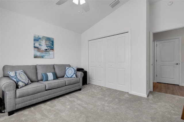 living room with ceiling fan, light colored carpet, and high vaulted ceiling