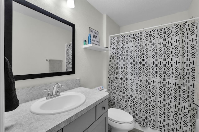 bathroom featuring a textured ceiling, vanity, toilet, and walk in shower