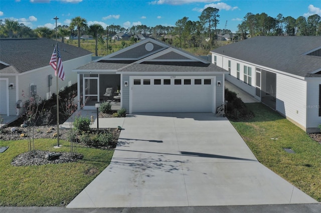 view of front of house with a garage, a front lawn, and a sunroom