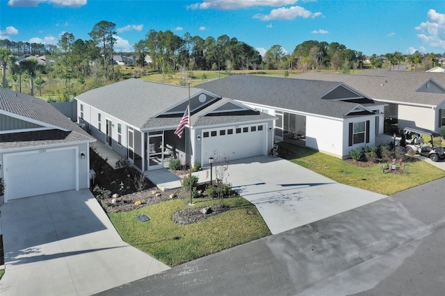 ranch-style house featuring a sunroom, a front lawn, and a garage