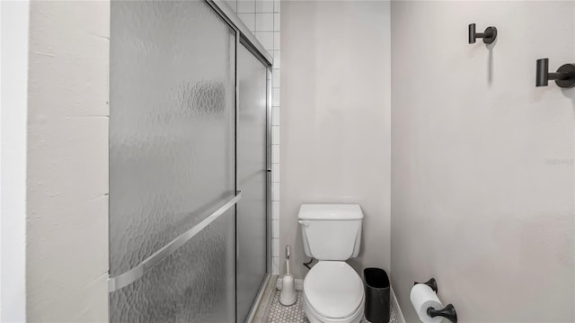 bathroom with toilet and an enclosed shower