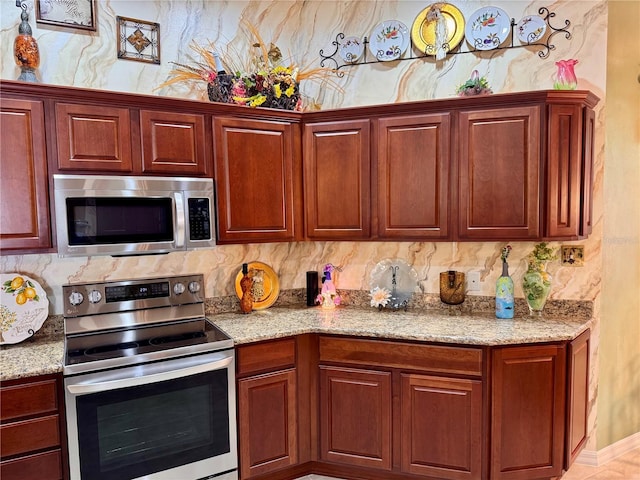 kitchen featuring light stone countertops and stainless steel appliances