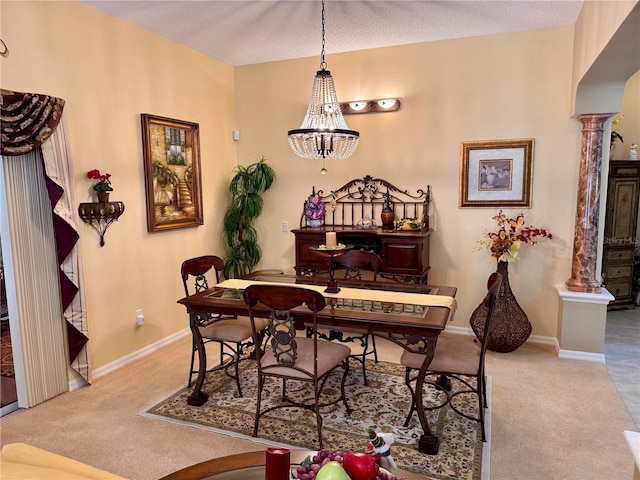 carpeted dining space featuring a notable chandelier, a textured ceiling, and decorative columns