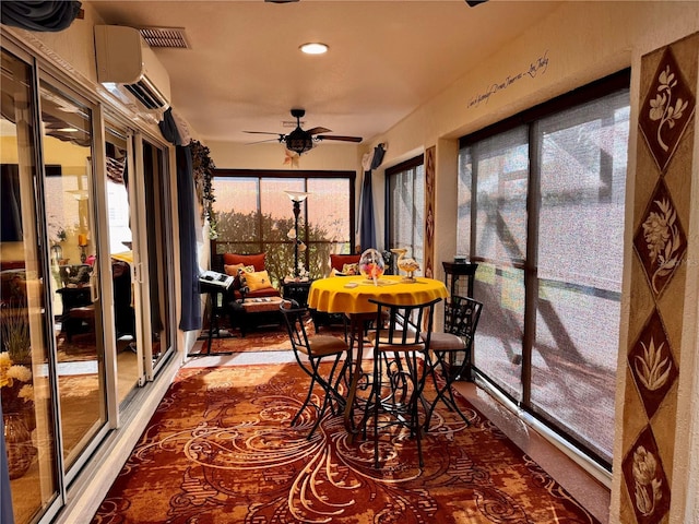 sunroom / solarium featuring a wall unit AC and ceiling fan