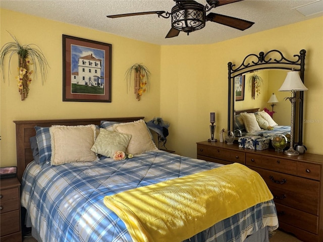 bedroom with ceiling fan and a textured ceiling