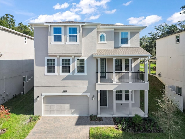 view of front of home featuring a porch, a garage, and a balcony