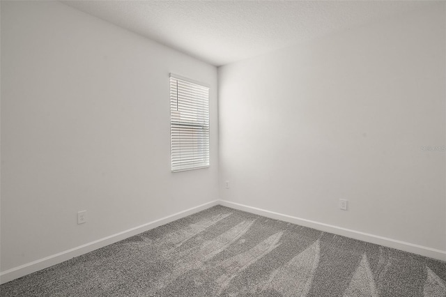 carpeted empty room with a textured ceiling