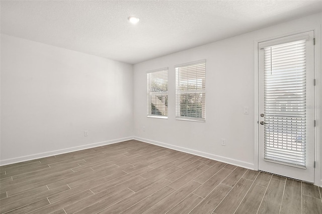 spare room featuring hardwood / wood-style flooring and a textured ceiling