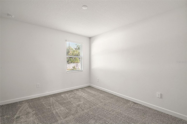 carpeted spare room with a textured ceiling