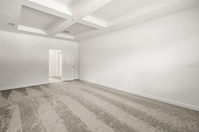 spare room featuring beamed ceiling, coffered ceiling, and carpet floors