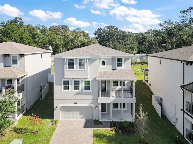 view of front of home featuring a balcony, a garage, and a front lawn