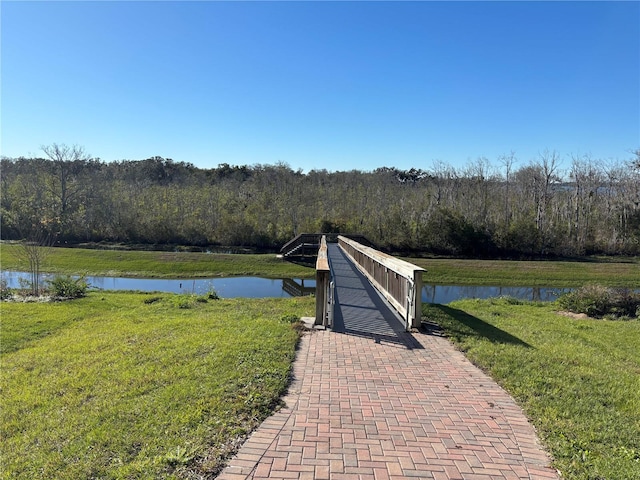 dock area with a water view and a yard