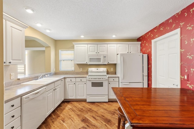 kitchen featuring light wood-type flooring, white appliances, and white cabinetry