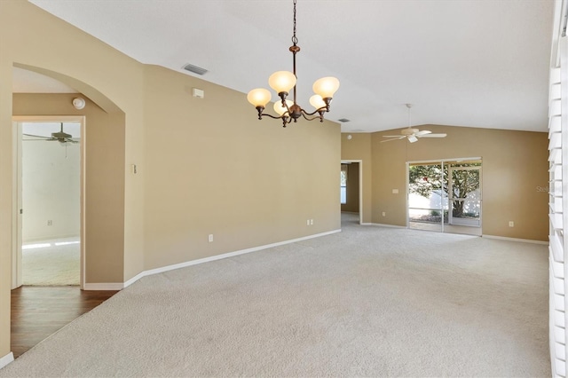 carpeted spare room with ceiling fan with notable chandelier and lofted ceiling