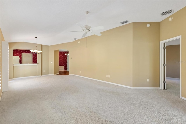 carpeted spare room featuring ceiling fan with notable chandelier and lofted ceiling