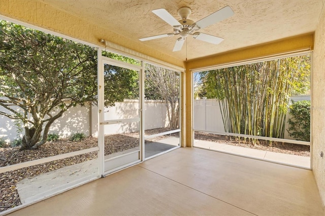 unfurnished sunroom featuring a wealth of natural light and ceiling fan