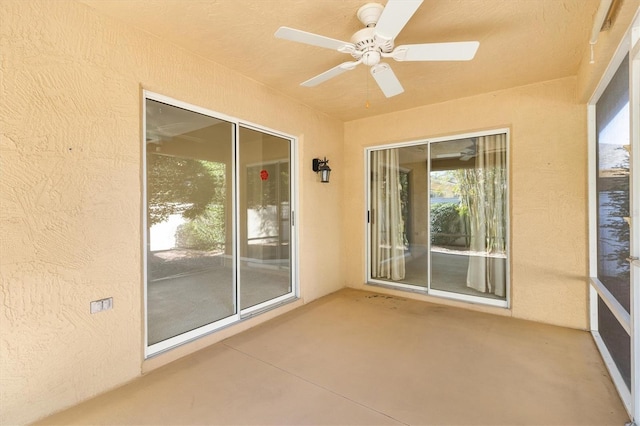 unfurnished sunroom featuring ceiling fan