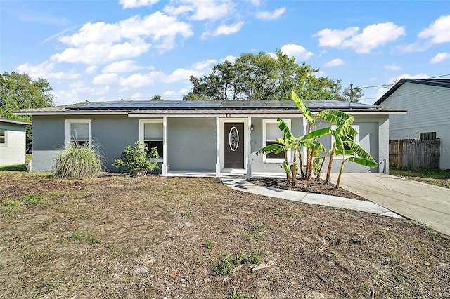 single story home with covered porch and solar panels