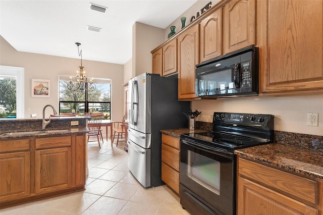 kitchen featuring sink, dark stone counters, a notable chandelier, and black appliances