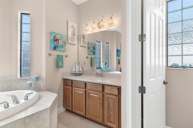 bathroom with tile patterned flooring, vanity, and tiled bath