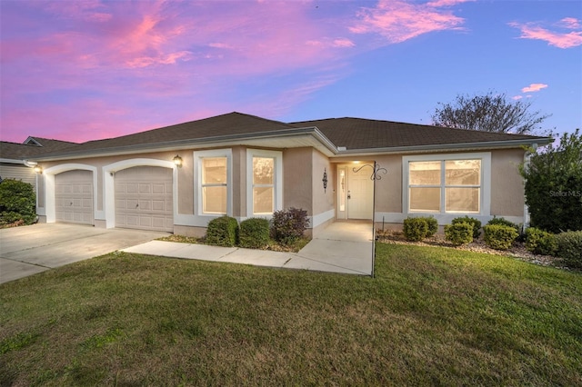 ranch-style home with a garage and a lawn