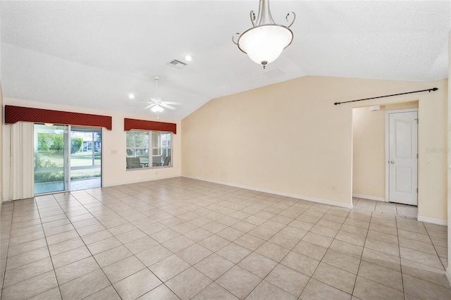 spare room with ceiling fan, light tile patterned floors, and vaulted ceiling