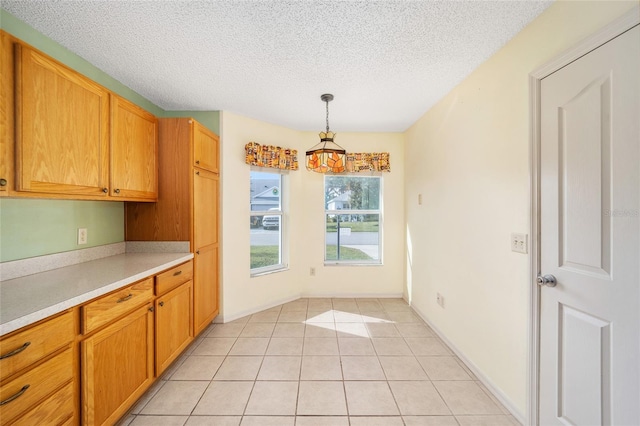 kitchen featuring pendant lighting, a textured ceiling, and light tile patterned floors