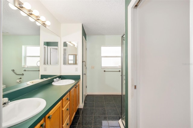 bathroom featuring a shower with door, vanity, and a textured ceiling