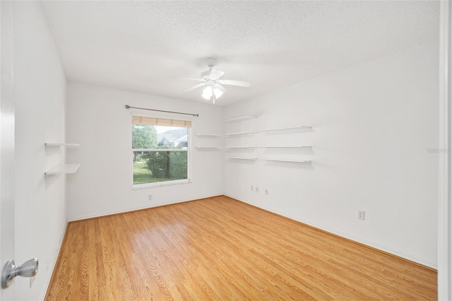 unfurnished room with a textured ceiling, light hardwood / wood-style floors, and ceiling fan