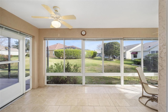 unfurnished sunroom with ceiling fan and a healthy amount of sunlight