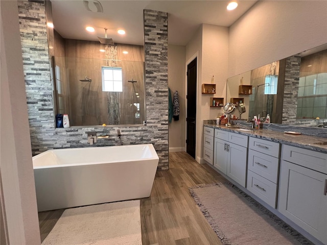 bathroom with vanity, plus walk in shower, and hardwood / wood-style floors