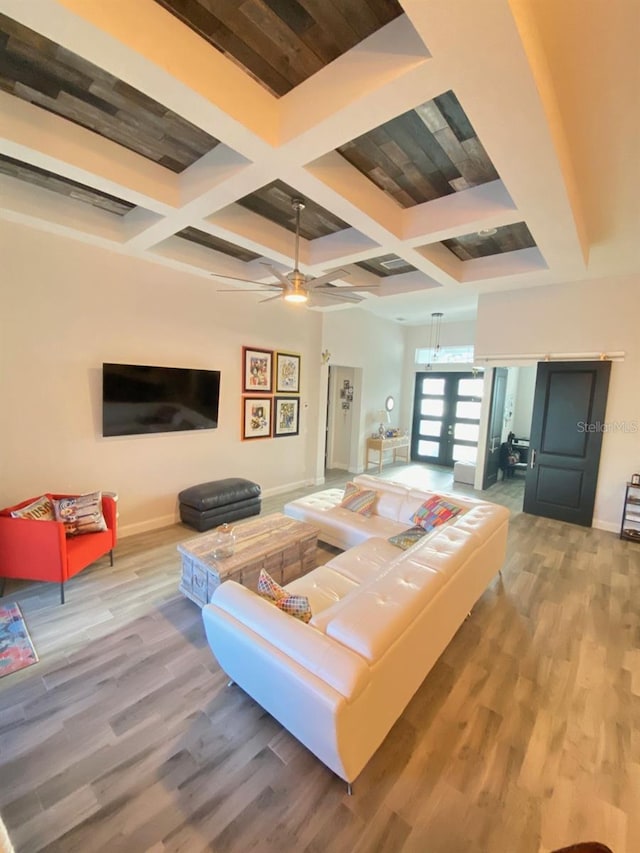 living room with hardwood / wood-style flooring, coffered ceiling, beam ceiling, and french doors