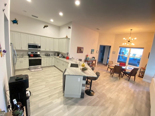 kitchen featuring a breakfast bar, pendant lighting, sink, kitchen peninsula, and stainless steel appliances