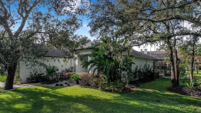 view of side of property featuring a lanai and a yard