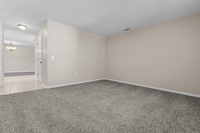 unfurnished room featuring light colored carpet and a notable chandelier